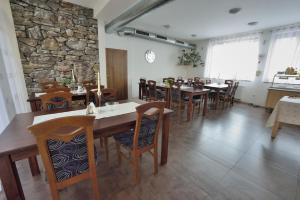 a dining room with tables and chairs and a stone wall at Penzion Best in Moravská Třebová