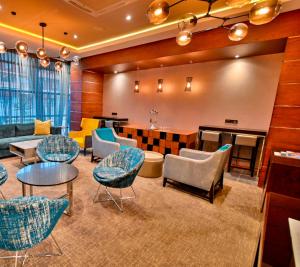 a lobby with chairs and tables and a bar at Premier Splendid Inn Bloemfontein in Bloemfontein