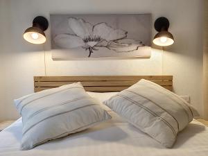 - une chambre avec un lit avec deux oreillers et un tableau dans l'établissement Le Tisserand by Cocoonr, à Lyon