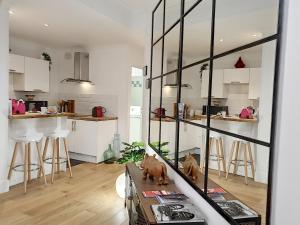 a kitchen with white cabinets and a dog on a table at Le Tisserand by Cocoonr in Lyon