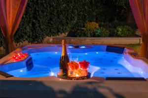 a hot tub with a bottle of wine and a glass at Villa Roko- the spacious luxury in Trogir