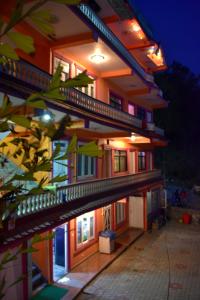 un bâtiment avec une façade éclairée la nuit dans l'établissement Hotel Santana, à Pokhara