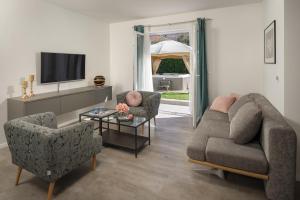 a living room with two chairs and a couch and a tv at Villa Roko- the spacious luxury in Trogir