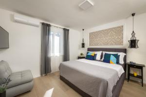 a bedroom with a large bed and a chair at Villa Roko- the spacious luxury in Trogir +31 photos