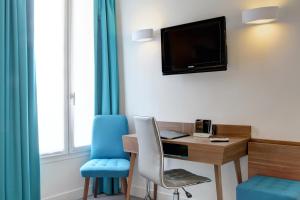 a living room with a tv and a chair at Best Western Plus 61 Paris Nation Hotel in Paris