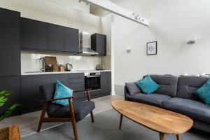 a living room with a couch and a table at Queens Park by Viridian Apartments in London