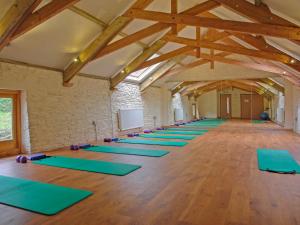 a large room with a row of yoga mats at Fixit Cottage in Kingsbridge
