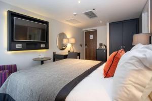 a bedroom with a large bed with a flat screen tv at Ten Hill Place, WorldHotels Distinctive in Edinburgh +84 photos