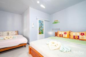 two beds in a room with white walls at Baan Kokaew Chiang Khan in Chiang Khan