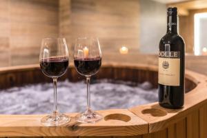 ザコパネにあるGóralska Dolina Jacuzzi & Saunaのホットタブのそばでの赤ワイン2杯