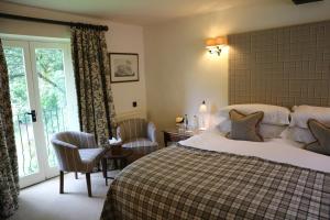 a hotel room with a bed and a window at The Bay Tree Hotel in Burford