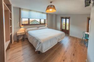 Un dormitorio con una cama grande y una ventana. en Casa Néboa., en Negreira