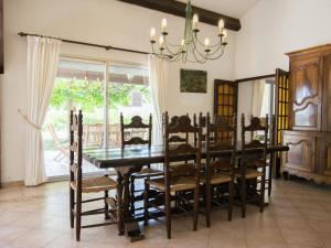 a dining room with a table and chairs and a chandelier at Villa in Campagnan with Pool and Vineyard Views in Campagnan