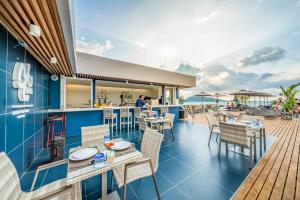 
a patio area with tables, chairs, and tables at Hotel Clover Patong Phuket - SHA Plus in Patong Beach
