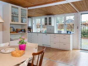 a kitchen with white cabinets and a table at 6 person holiday home in Glesborg in Glesborg