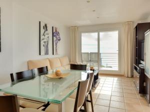 uma sala de jantar com uma mesa de vidro e cadeiras em Quaint Apartment close to the Seabeach em Vinarós