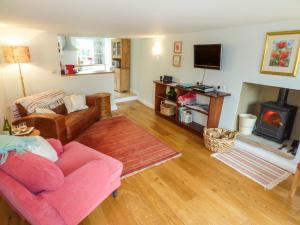 a living room with a pink couch and a fireplace at Garden Cottage in Richmond