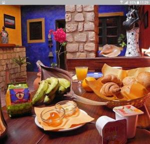 a table topped with a bowl of bananas and bread at Sakaroule B&B in Santa Maria