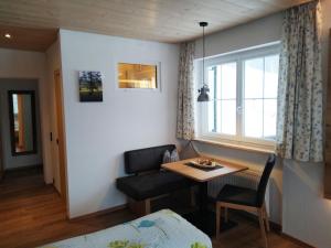 a living room with a table and a couch and a window at Jagdhaus Hiemer in Balderschwang