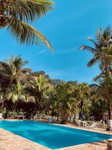 basen z palmami i niebieskim niebem w obiekcie Boiçucanga Completo à Beira Mar w mieście Boiçucanga