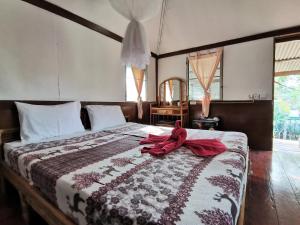 a bedroom with a bed with a red ribbon on it at Sleep Whale Lanta in Ko Lanta