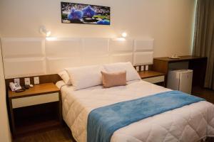 Habitación de hotel con 1 cama y 2 mesas en POUSADA ESTÂNCIA en Penedo