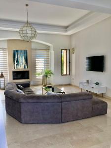 Una gran sala de estar con un sofá y un televisor. en La Rose des Sables, en Marrakech