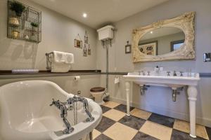 a bathroom with a tub and a sink at The Bulls Head Hotel in Bromley +39 photos