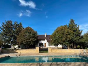 a swimming pool in front of a house at VILLA BLANCA in Olías del Rey