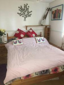 um quarto com uma cama branca com almofadas em Beautiful Bungalow Home Droitwich SPA em Droitwich