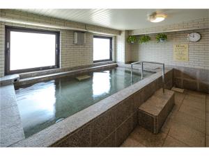 a swimming pool in a building with water in it at Hotel Hokke Club Kumamoto in Kumamoto