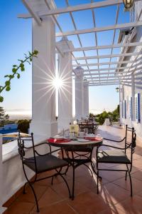 eine Terrasse mit einem Tisch und Stühlen auf dem Balkon in der Unterkunft Stillness Manor Estate & Spa in Constantia
