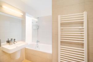 a bathroom with a tub, sink and mirror at Old Town Square Premium Apartments in Prague