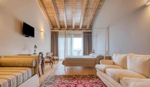 uma sala de estar com um sofá e uma cama em Il Bagnolo Eco Lodge em Salò