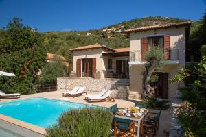 a villa with a swimming pool and a house at Arodo Seaside Villas - Villa Christina in Sivota