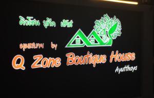 un cartello per una casa gonfiabile con alcune insegne al neon di Q Zone Boutique House a Phra Nakhon Si Ayutthaya