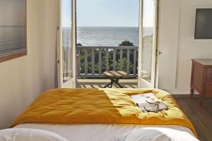 a bedroom with a bed with a view of the ocean at Hotel Bellevue in Villerville