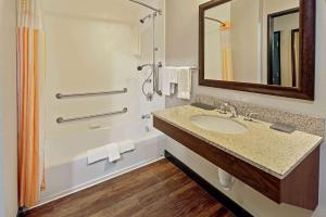 a bathroom with a sink and a tub and a mirror at La Quinta by Wyndham Butte in Butte