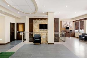 a lobby with a bar with chairs and a tv at La Quinta by Wyndham Oshawa in Oshawa