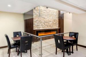 a dining room with two tables and a fireplace at La Quinta by Wyndham Oshawa in Oshawa