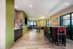 a kitchen with green walls and a bar with stools at La Quinta by Wyndham Pomona in Pomona