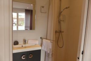 a bathroom with a sink and a shower with a mirror at Maison 4 personnes en bord de mer - Golfe du Morbihan in Baden