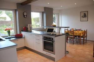a kitchen with a laptop on top of a stove at Maison 4 personnes en bord de mer - Golfe du Morbihan in Baden +35 photos