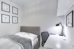a bedroom with a bed and a desk with a lamp at Apartament 200 Apartamenty No.1 Ogród, parking w Centrum in Szczecin