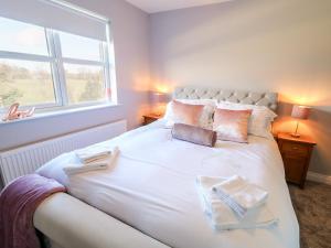 a bedroom with a large white bed with towels on it at Culmore Point in Culmore