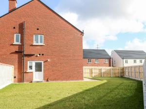 a brick house with a grass yard in front of it at Culmore Point in Culmore