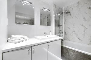 a white bathroom with a sink and a shower at Apartament 200 Apartamenty No.1 Ogród, parking w Centrum in Szczecin