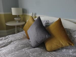 a bed with four pillows on top of it at Marine View Guest House in Worthing