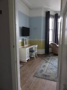 a room with a desk and a tv on the wall at Marine View Guest House in Worthing