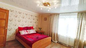 マグニトゴルスクにあるКвартира 1 комнатная у Гостиного Двораのベッドルーム1室(赤いシーツ付きのベッド1台、窓付)